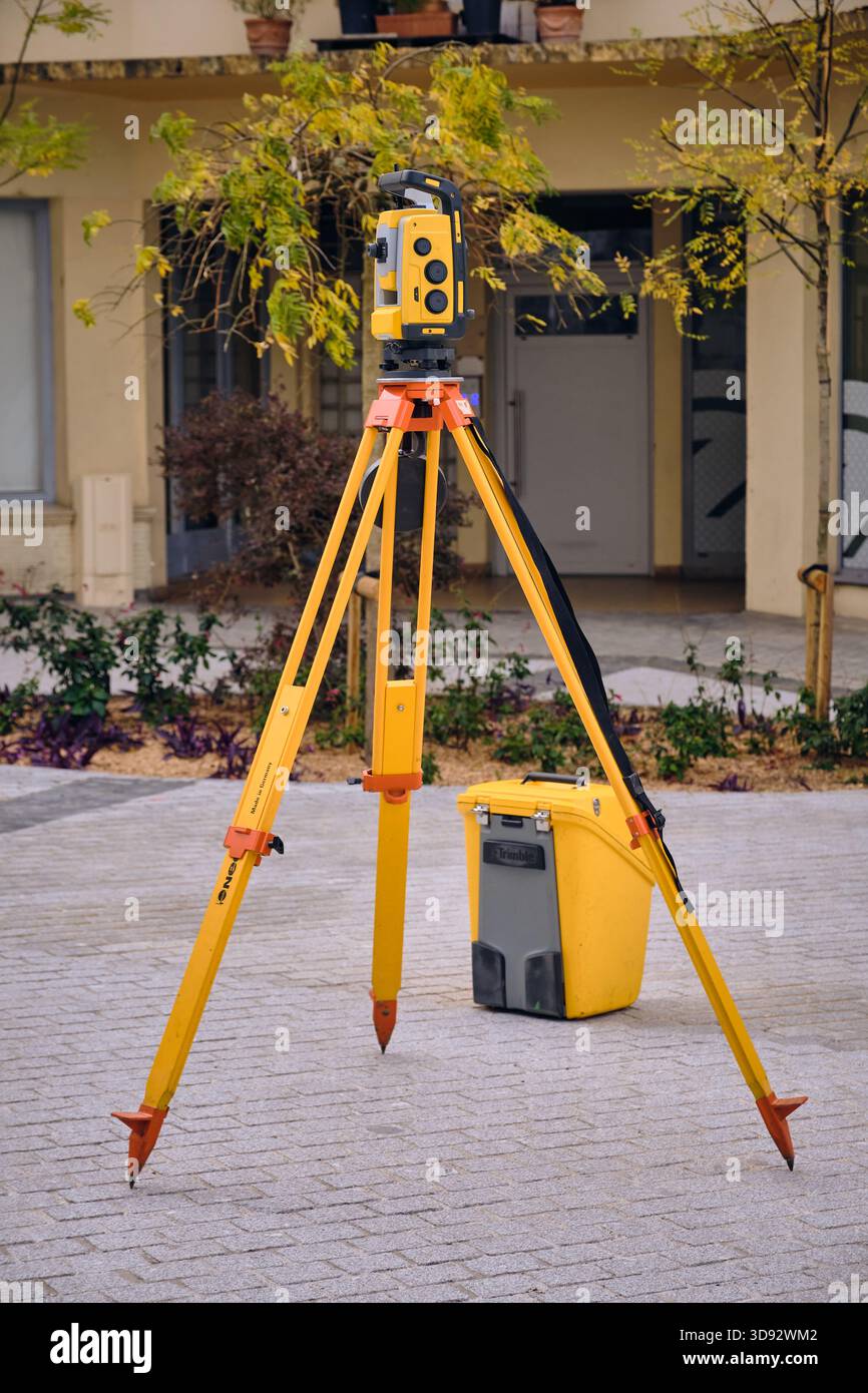 Lourdes, Frankreich - 19. November 2025: Ein gelbes Trimble-Totalstation-Theodolith-Vermessungsinstrument wird auf einem Stativ in Lourdes France aufgestellt. Dieses Bild ist Stockfoto