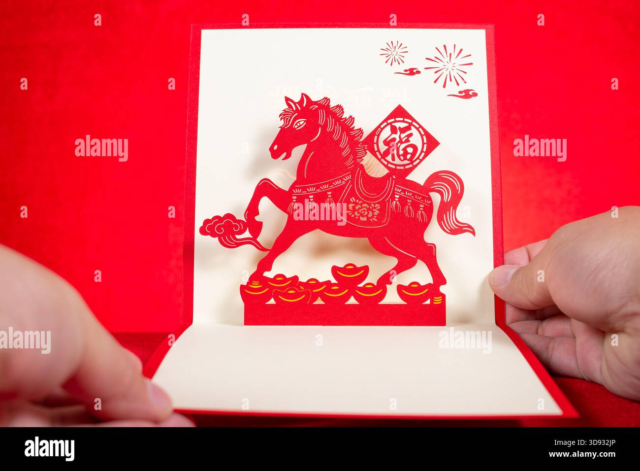 Mann mit einer 3D-Geschenkkarte eines Pferdes auf rotem Hintergrund bei horizontaler Komposition die chinesische Wortübersetzung ist Vermögen Stockfoto
