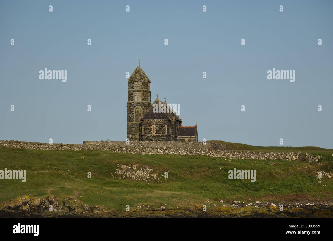 Die St. Edward’s Church, heute entweiht und nicht mehr genutzt, steht allein auf Sanday, Canna, auf den kleinen Inseln Schottlands, mit einem hellblauen Himmel über ihnen. Stockfoto