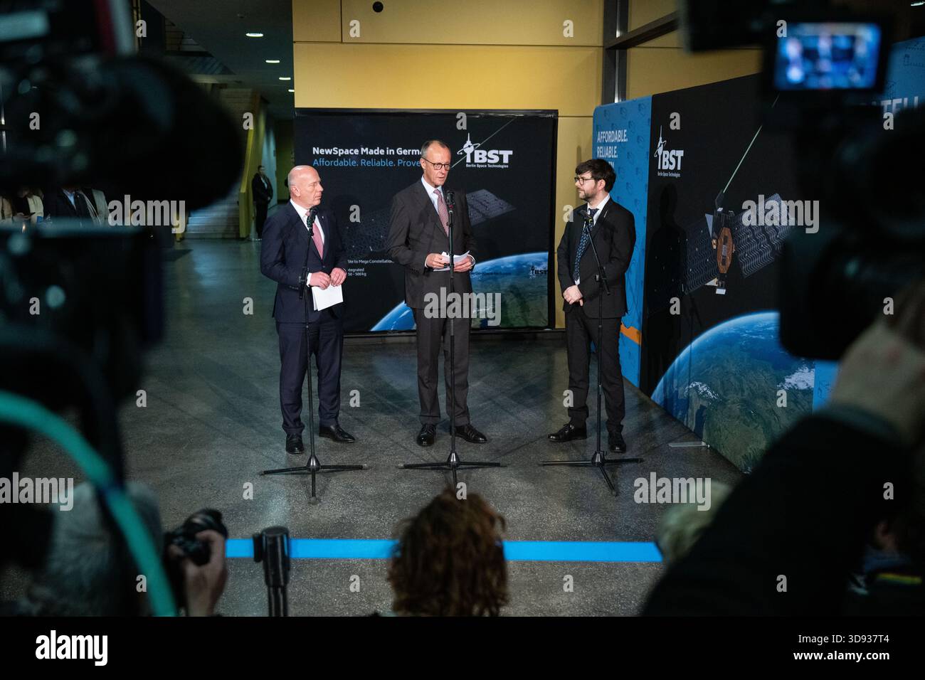 Berlin, Deutschland. Dezember 2025. Kai Wegner (CDU, l-r), Regierender Bürgermeister von Berlin, Bundeskanzler Friedrich Merz (CDU) und Tom Segert, Geschäftsführer von Berlin Space Technologies, sprechen auf einer Pressekonferenz nach einem Besuch bei Berlin Space Technologies. Quelle: Christophe Gateau/dpa/Alamy Live News Stockfoto