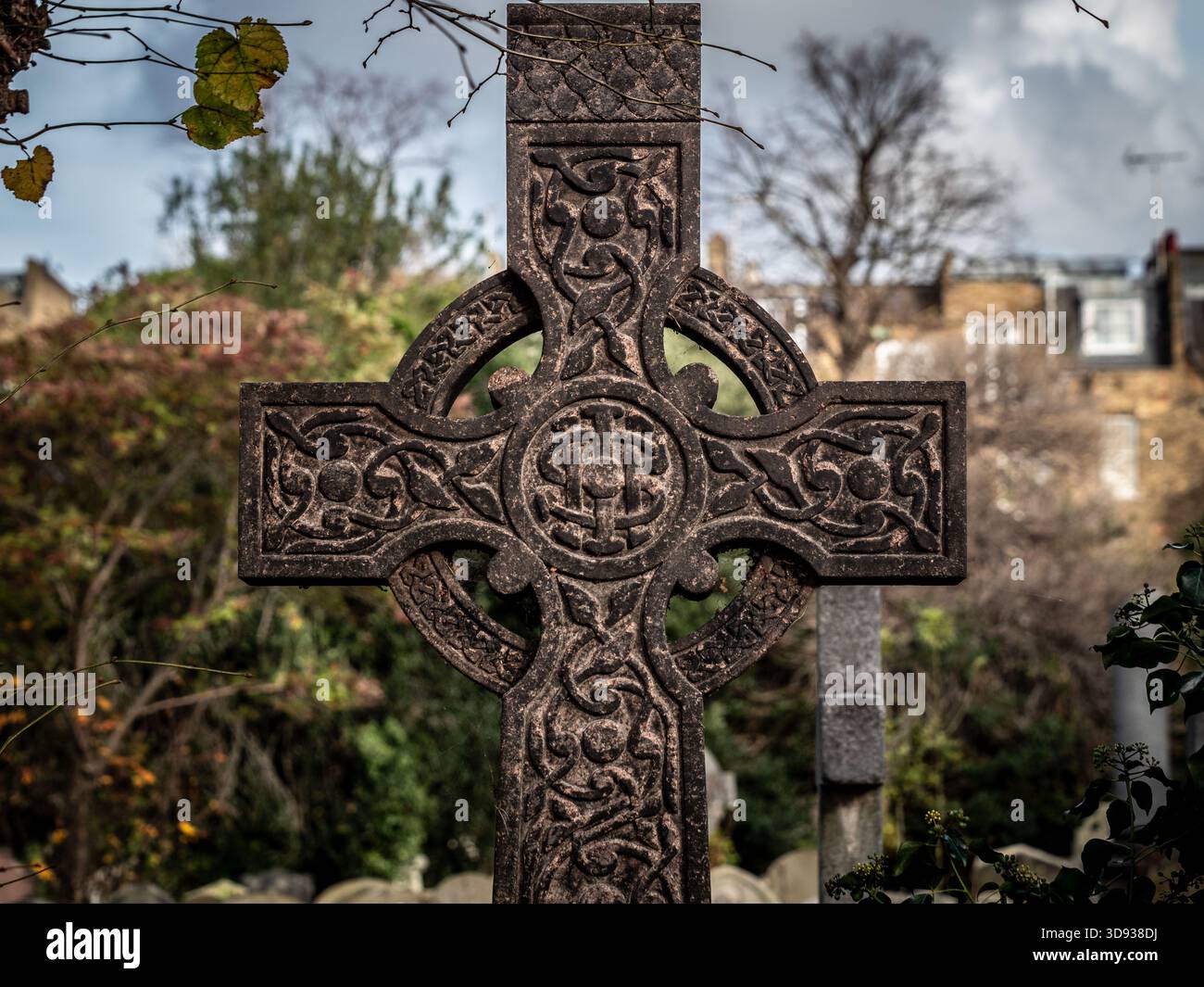 Gravierter Grabstein des keltischen Kreuzes, geschwärzt durch Verschmutzung auf dem Brompton Cemetery, London. UK Stockfoto