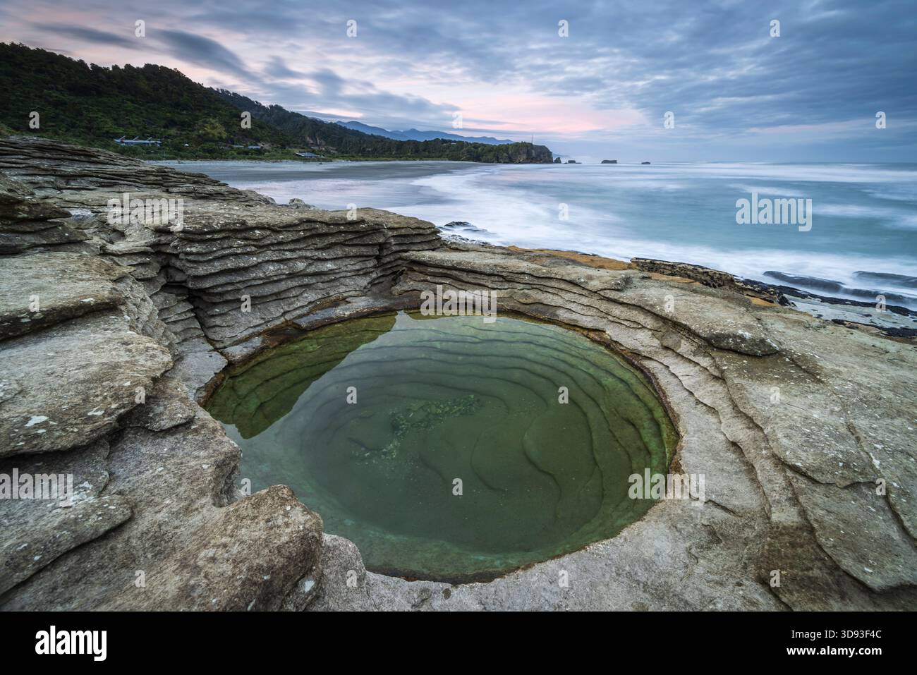 Kreisförmiges Kalksteinbecken an der Küste von Punakaiki im Paparoa-Nationalpark, Westküste, Südinsel, Neuseeland. Herbst (Mai) 2025. Stockfoto