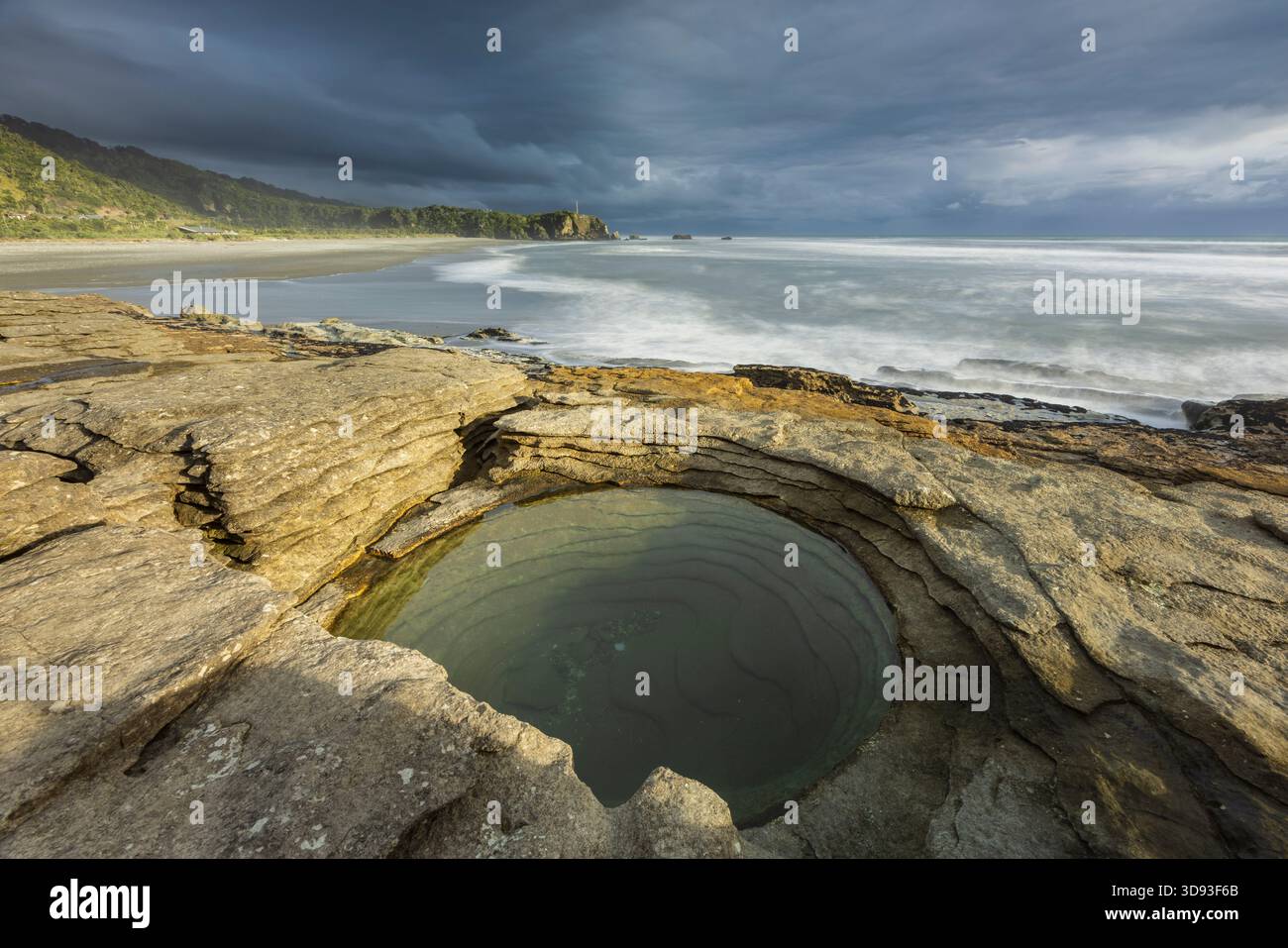 Kreisförmiges Kalksteinbecken an der Küste von Punakaiki im Paparoa-Nationalpark, Westküste, Südinsel, Neuseeland. Herbst (Mai) 2025. Stockfoto