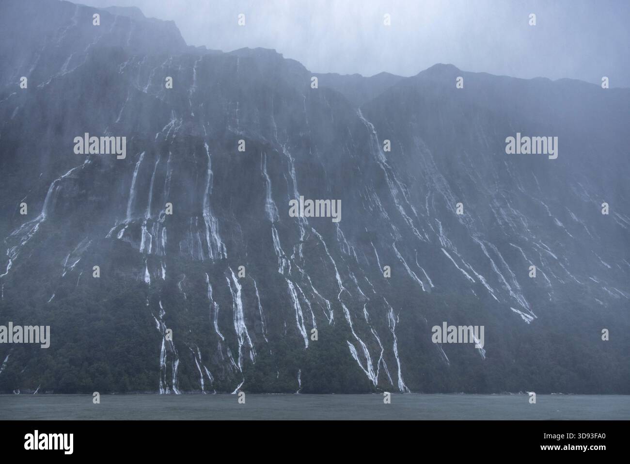Kaskaden vorübergehender Wasserfälle während eines Sturms am Milford Sound im Fiordland National Park, Südinsel, Neuseeland. Herbst (Mai) 2025. Stockfoto
