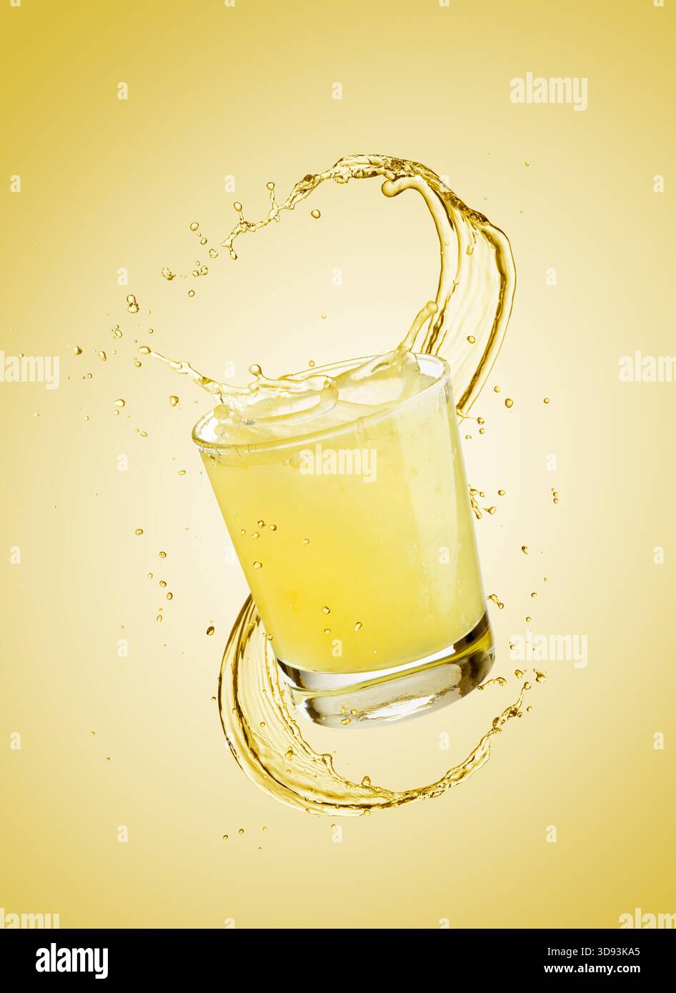 Glas Limonade mit Spritzern auf gelbem Hintergrund. Stockfoto