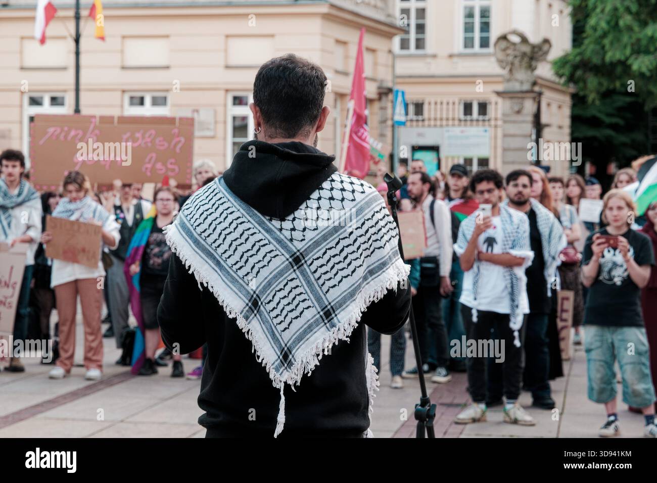 Ein Sprecher mit einem Keffiyeh spricht während einer öffentlichen Demonstration eine pro-palästinensische Menge an. Stockfoto