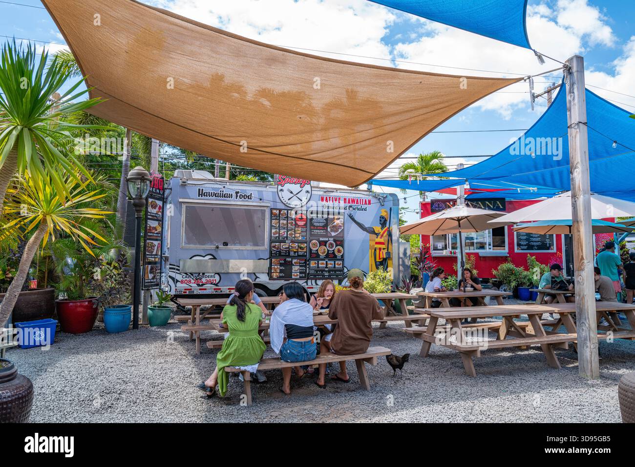 Hungrige Besucher essen an Picknicktischen in den South Maui Gardens, die eine Vielzahl von Food Trucks in einem 6 Hektar großen Restaurant-, Shopping- und Unterhaltungsangebot bieten Stockfoto