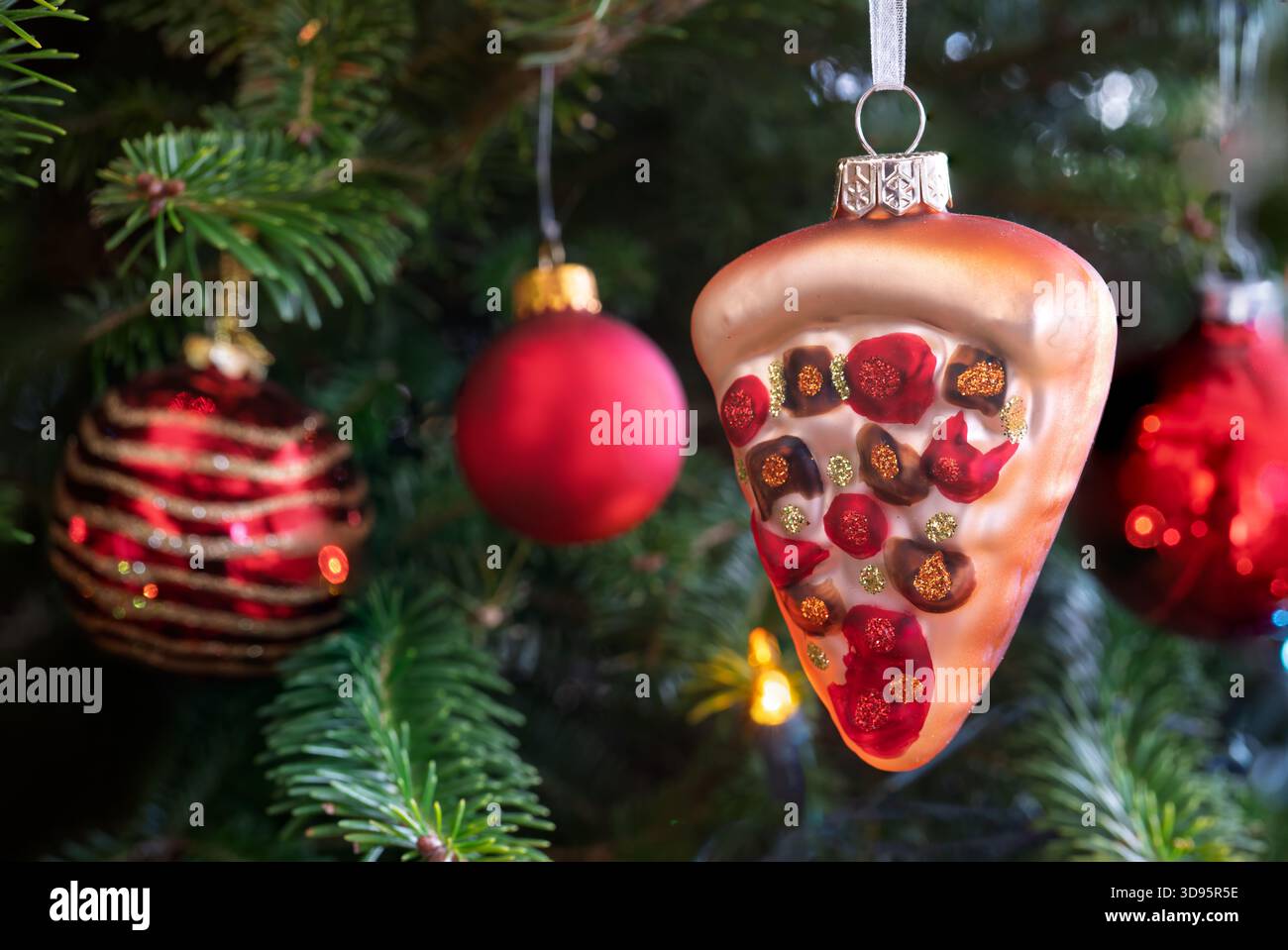 Ein Pizzablättchen-Schmuckstück, das an einem Weihnachtsbaum hängt. Stockfoto