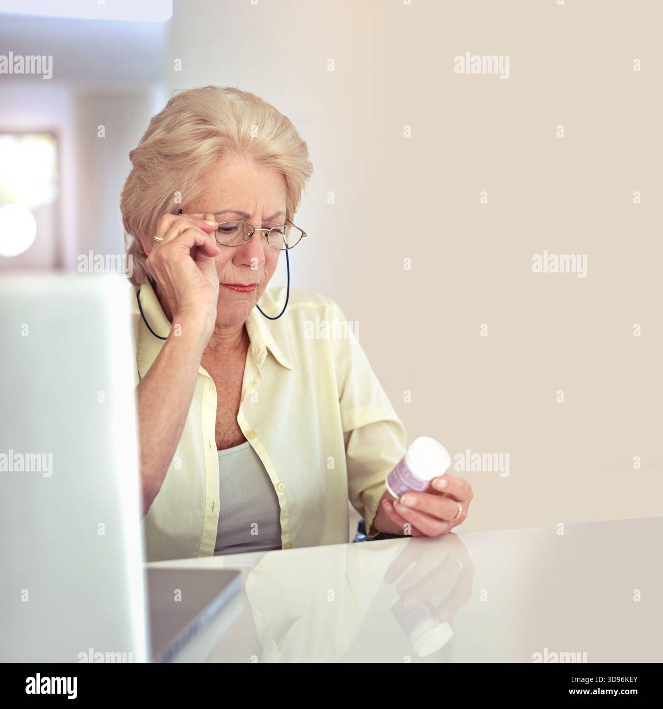 Laptop, Brille oder alte Frau mit Pillen zu Hause für Nebenwirkungen, Dosierungsinformationen oder Medikamentenvorteile. Brillen, Senioren und überprüfen Sie das Etikett der Tabletten Stockfoto