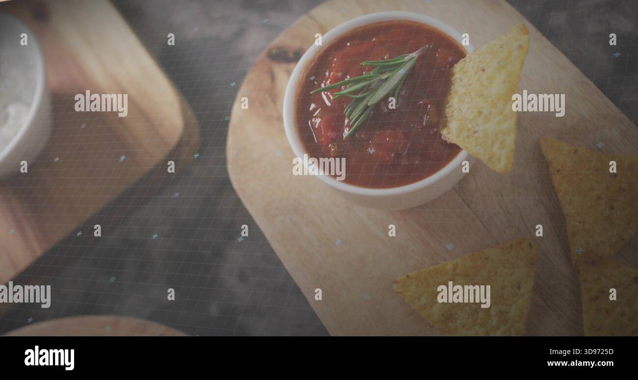 Mit weißer Schüssel mit Tomatensalsa und Rosmarin auf Holzbrett in der Küche, Tortilla Chips Stockfoto