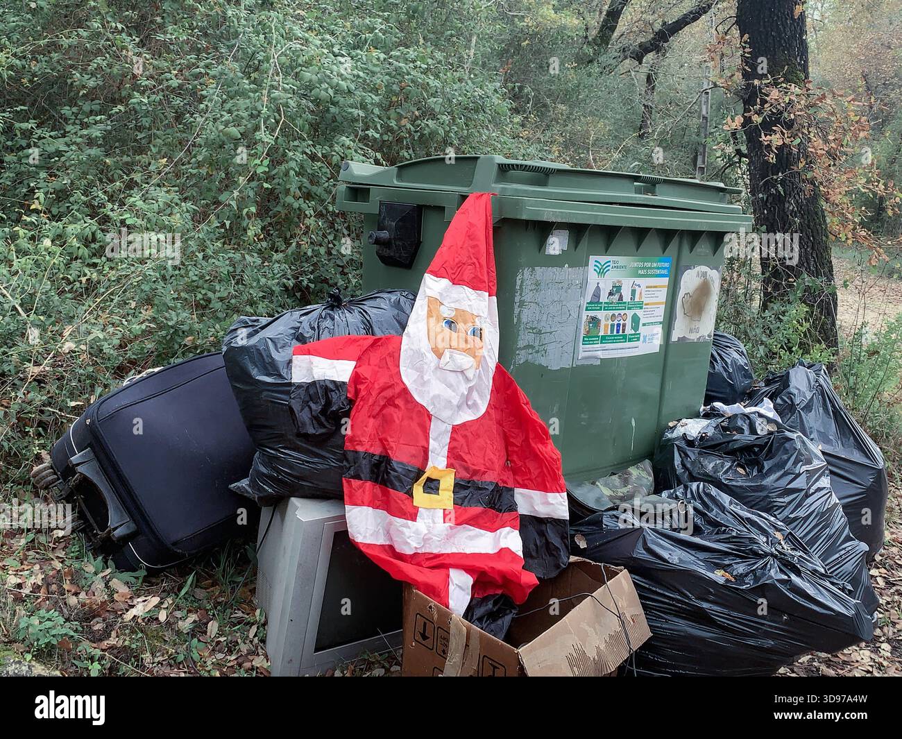 Entlüfteter Weihnachtsmann, der von Mülltonnen weggeworfen wurde - Smartphone-aufgenommenes Stockfoto