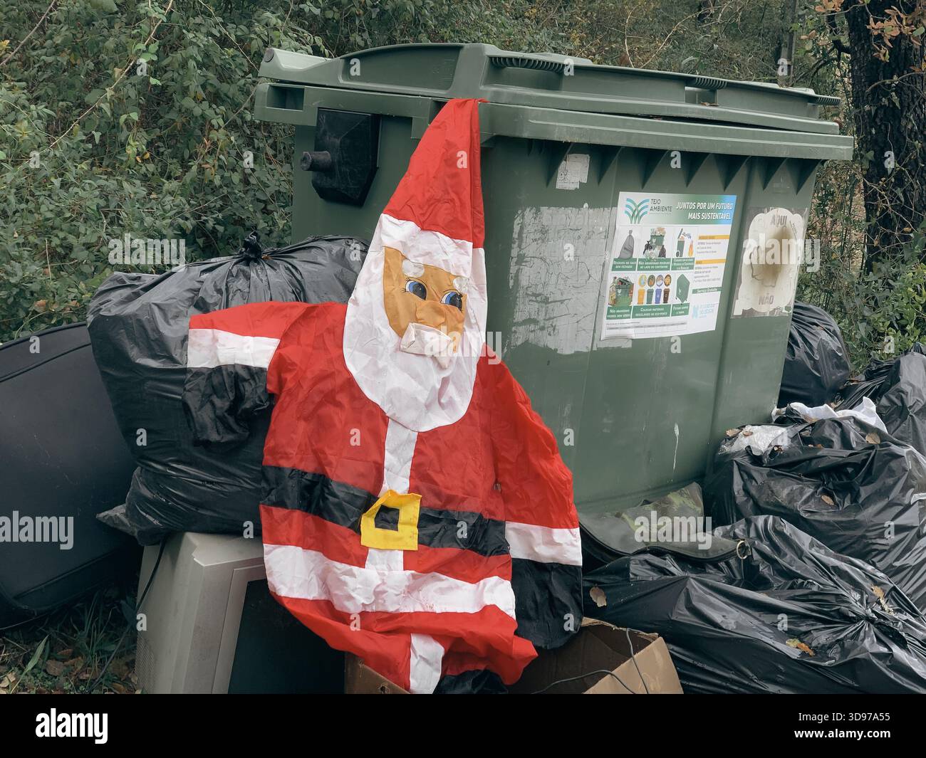 Entlüfteter Weihnachtsmann, der von Mülltonnen weggeworfen wurde - Smartphone-aufgenommenes Stockfoto