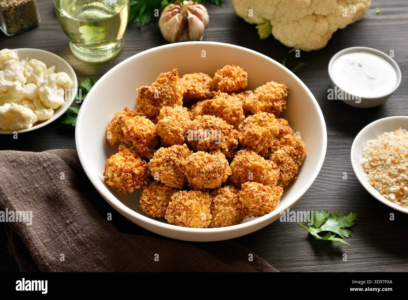 Panierter Ofen gebackene Blumenkohlbacken in einer Schüssel auf Holztisch. Stockfoto