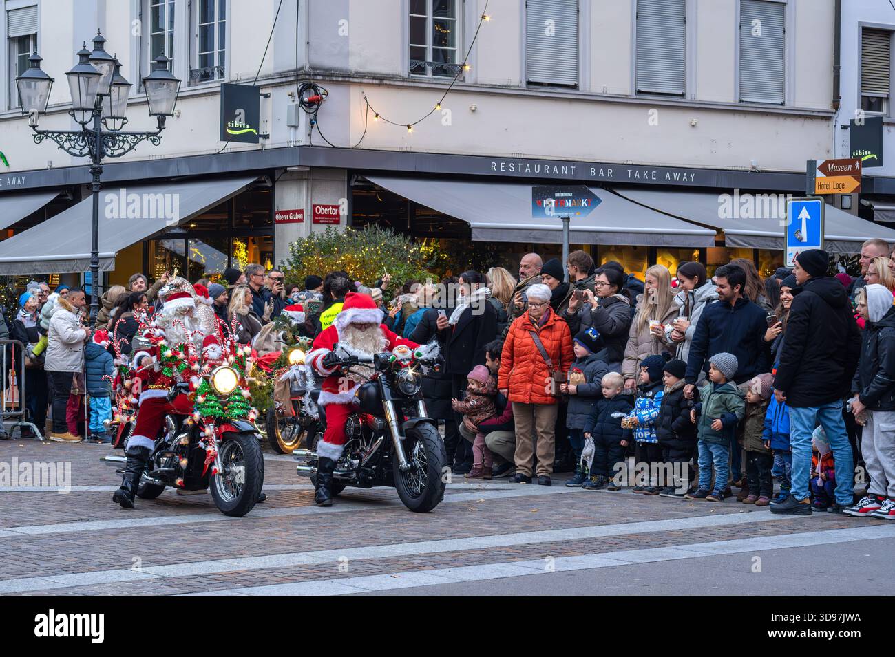 Winterthur, Schweiz - 30. November 2025: Eine festliche Paradeszene mit Weihnachtsmannsfiguren, die Motorräder fahren, umgeben von einer Menschenmenge, inkl. Stockfoto