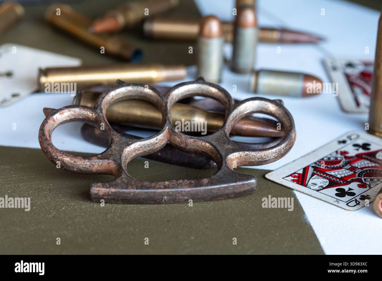 Ein paar altmodische Messingknöchel ist auf einem Tisch mit einem Kartenspiel. Bei den Karten handelt es sich um ein Standardspiel mit 52 Karten Stockfoto