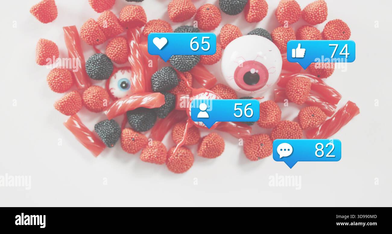 Mit roten und schwarzen Gummihaufen mit Lakritz- und Kunststoffaugen auf weißem Hintergrund, blauen Blasen Stockfoto