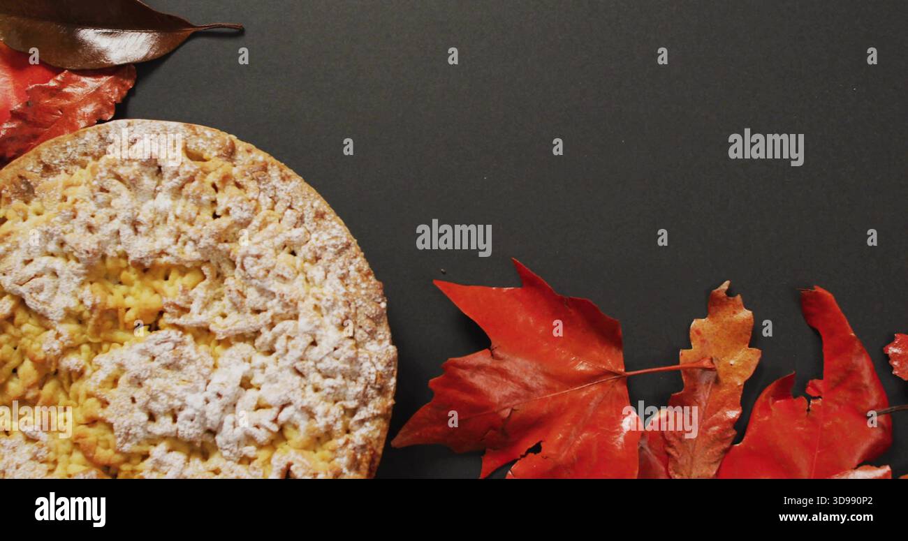 Mit rundem, mit Zucker bestäubtem Gebäck auf Holzkohleplatte, roten Orangenblättern Stockfoto