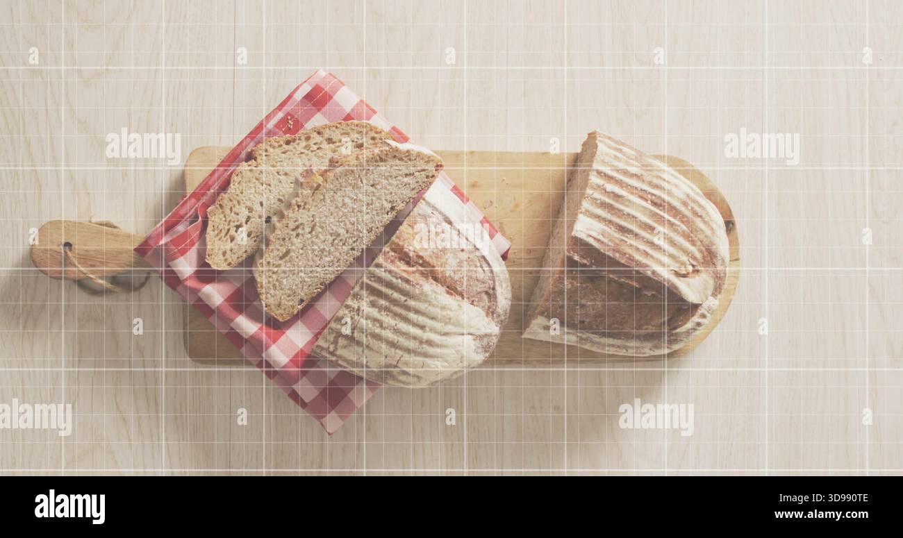 Zwei rustikale Sauerteiglaibe auf hellem Holztisch, Schneidebretter, Gingham-Tuch Stockfoto