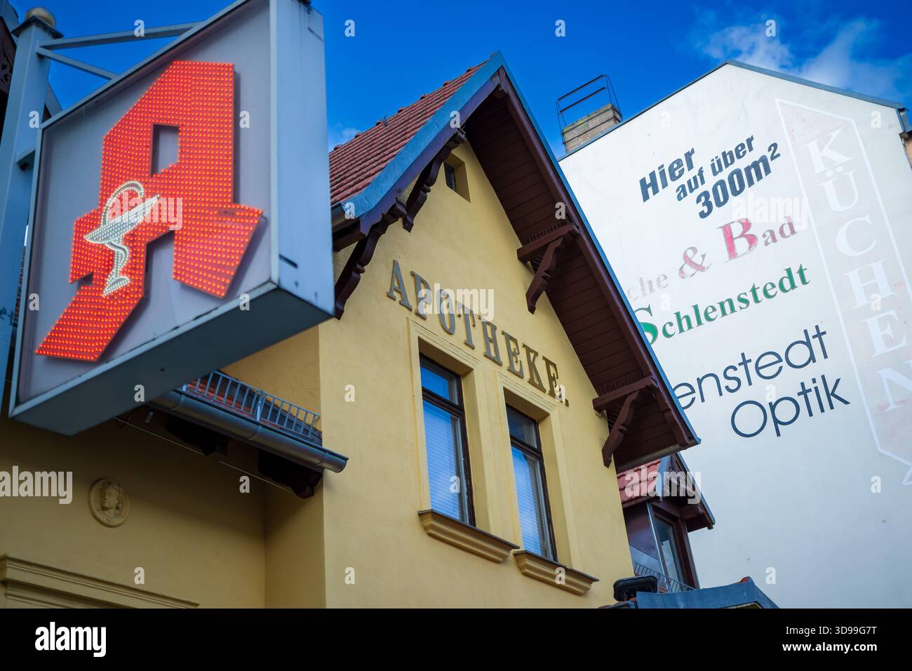 Historische Flora-Apotheke in Berlin-Weißensee mit ihrem ikonischen beleuchteten Apothekenschild und der traditionellen Fassade. Stockfoto