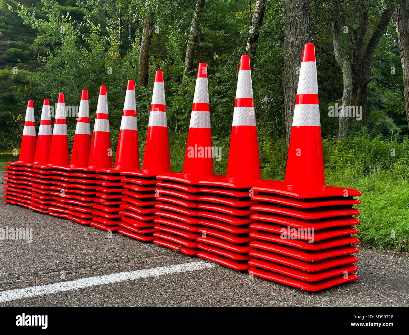 Zehn Haufen orangefarbener und weißer Plastikkegel in einer Reihe. Stockfoto