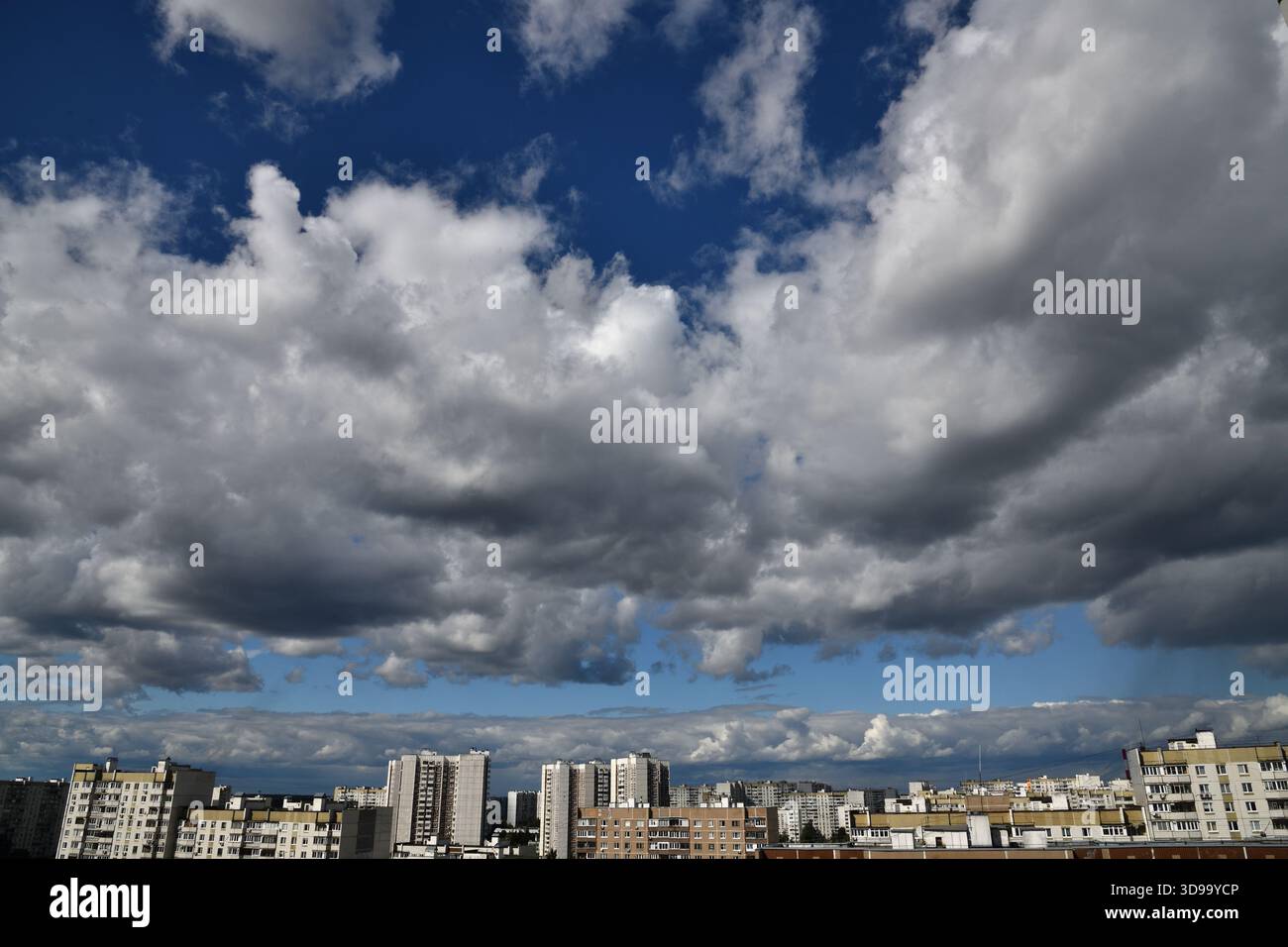 Wunderschöner dramatischer Himmel mit Kumuluswolken über der Stadt Stockfoto