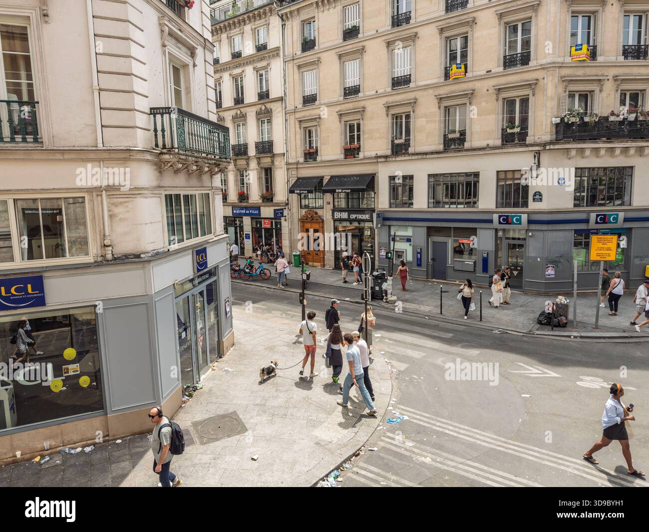 PARIS, FRANKREICH - 22. JUNI 2025: Straßenszene im Pariser Marais-Viertel mit Fußgängern, die in der Nähe von Boutiquen und Cafés vorbeikommen. Le marais ist ein Stadtteil Stockfoto