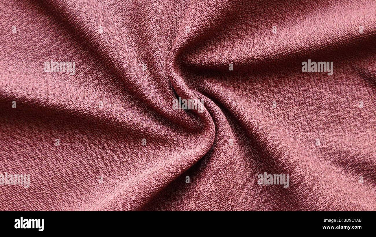 Nahaufnahme eines strukturierten Crepe-Stoffes in Mauve Pink als flacher, einfarbiger Hintergrund oder Textilmaterial Stockfoto
