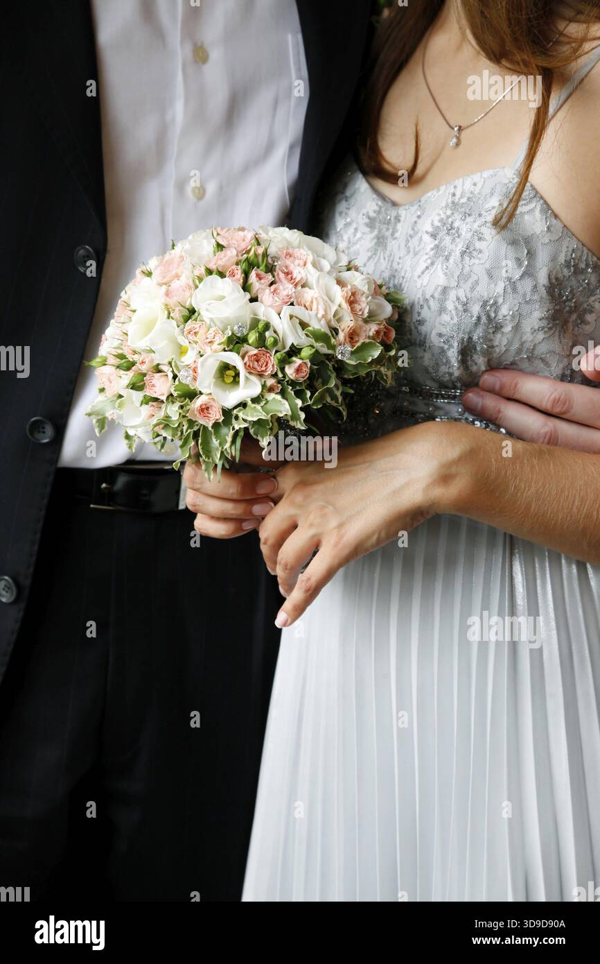 Blumenstrauß auf einem Hintergrund von einem Kleid der Braut und der Bräutigam Anzug Stockfoto