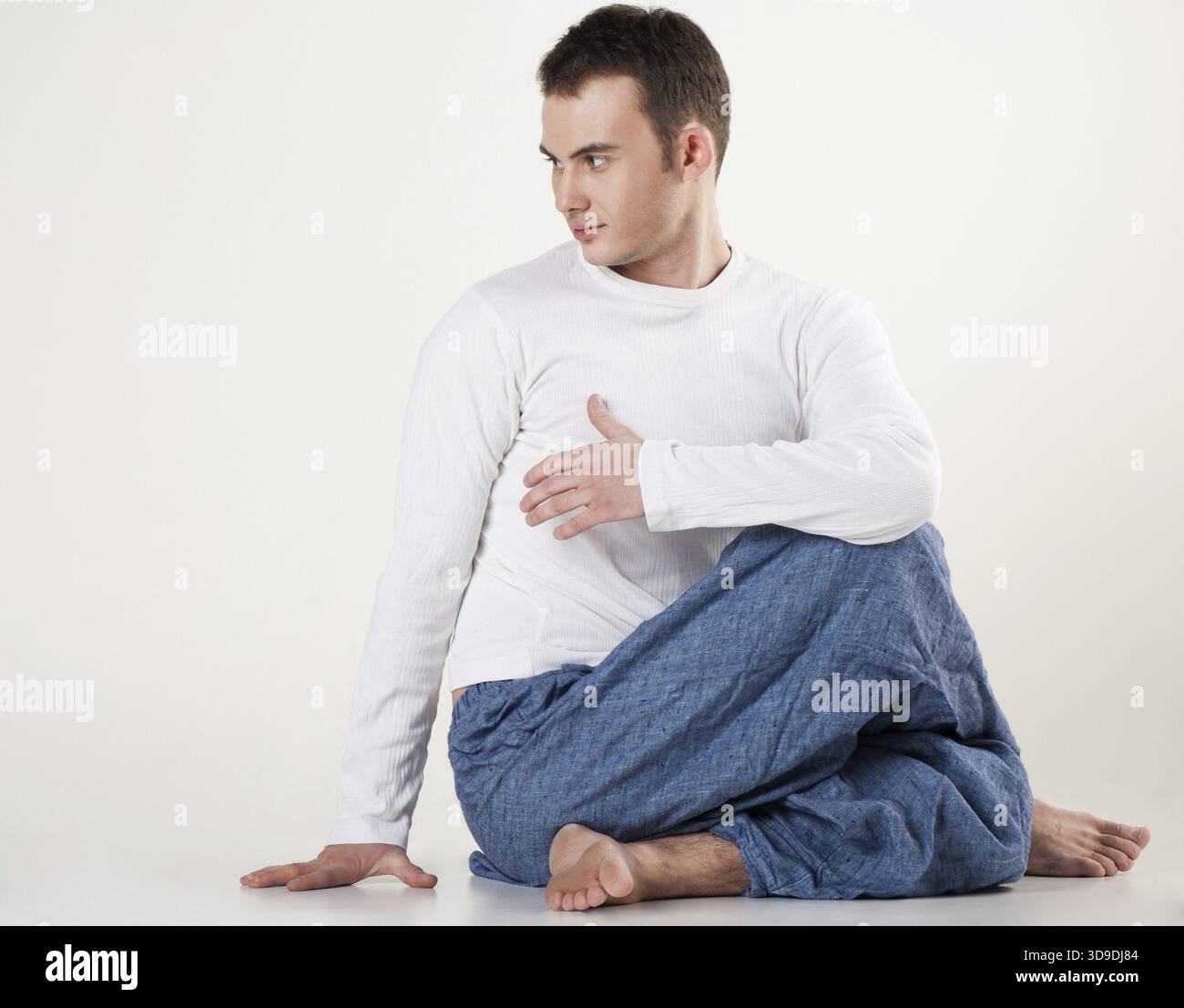 Porträt eines gesunden jungen Mannes beim Yoga - Wirbelsäulendrehung Stockfoto