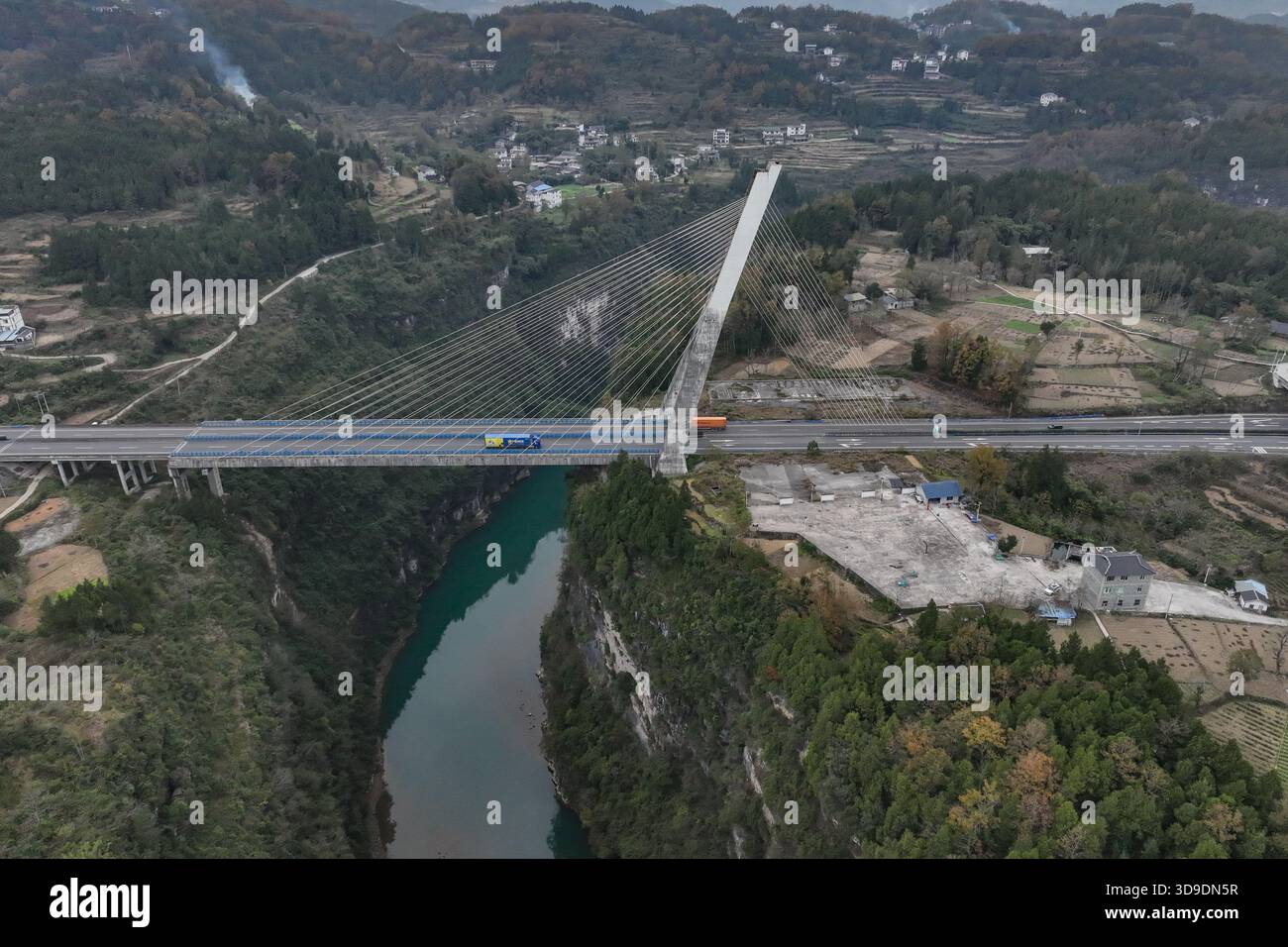 Zunyi, China. 4. Dezember 2025. Die Drohnenfotos erfassen die 224 Streckenkabel der Furongjiang River Bridge in der Provinz Guizhou im Südwesten Chinas. Sie ähneln Harfensaiten, wenn sie sich über dem Fluss erstrecken und das Bild einer „Harfe am Himmel“ schaffen. , 4. Dezember 2025. Die Brücke befindet sich im Kreis Zheng'an, Stadt Zunyi, südwestchinesischer Provinz Guizhou, und erstreckt sich insgesamt über 340 Meter mit einer Hauptspannweite von 170 Metern. Sein umgedrehter Y-förmiger Pylon ist 98,5 Meter hoch und damit Chinas erste bodenverankerte, einpylonseilige Betonbrücke. Quelle: Qu Honglun/China News Stockfoto