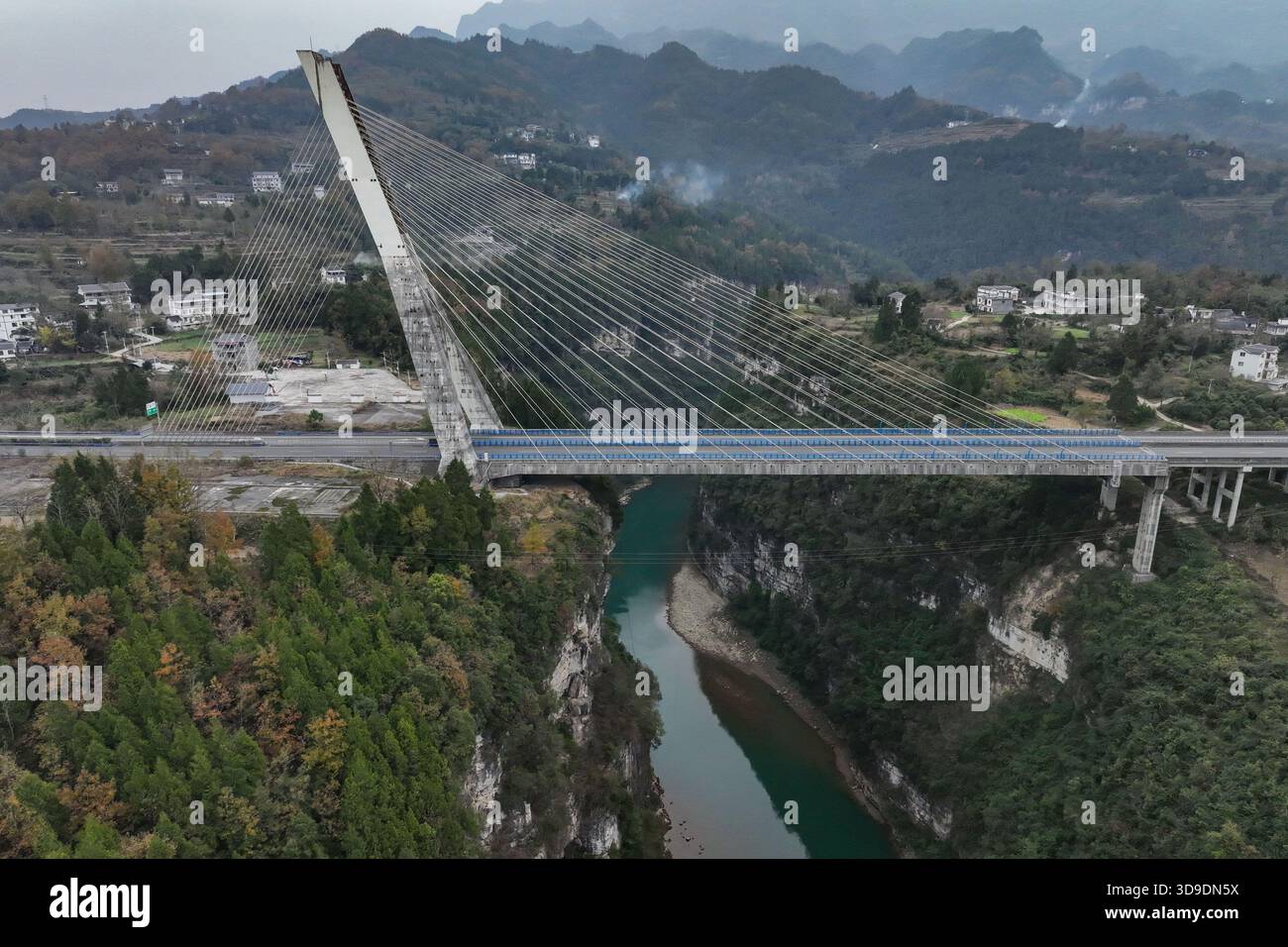 Zunyi, China. 4. Dezember 2025. Die Drohnenfotos erfassen die 224 Streckenkabel der Furongjiang River Bridge in der Provinz Guizhou im Südwesten Chinas. Sie ähneln Harfensaiten, wenn sie sich über dem Fluss erstrecken und das Bild einer „Harfe am Himmel“ schaffen. , 4. Dezember 2025. Die Brücke befindet sich im Kreis Zheng'an, Stadt Zunyi, südwestchinesischer Provinz Guizhou, und erstreckt sich insgesamt über 340 Meter mit einer Hauptspannweite von 170 Metern. Sein umgedrehter Y-förmiger Pylon ist 98,5 Meter hoch und damit Chinas erste bodenverankerte, einpylonseilige Betonbrücke. Quelle: Qu Honglun/China News Stockfoto