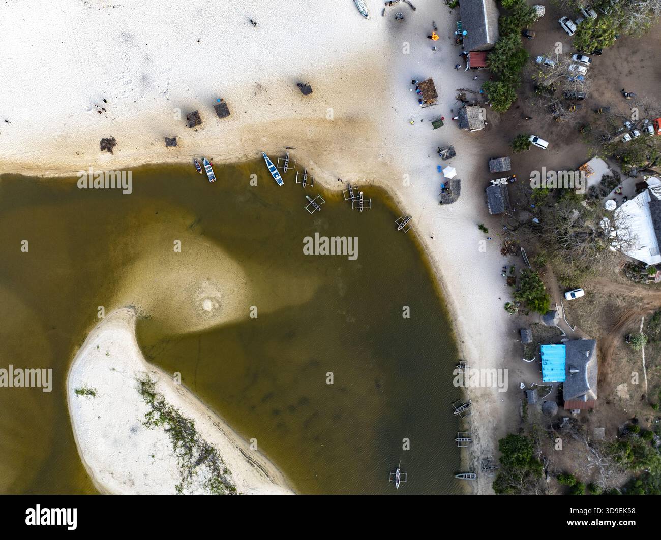 Aus der Vogelperspektive sehen Sie Boote, die in den ruhigen Gewässern ruhen, wo der Fluss auf das Ufer trifft, in starkem Kontrast zum Sandstrand, Diani, Kwale County, Ke Stockfoto