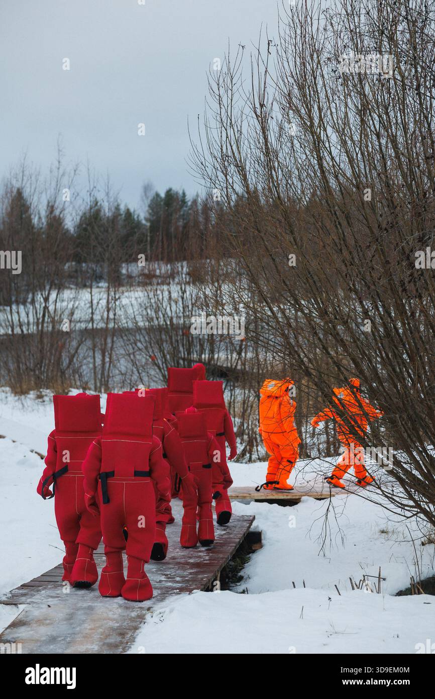 Rettungsteam In Roten Anzügen, Der Über Snowy Läuft Stockfoto