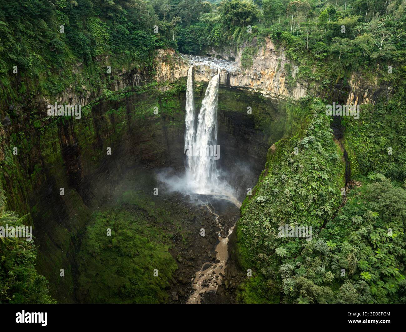Der Tumpak Sewu Wasserfall aus der Vogelperspektive stürzt über eine üppige, grüne Klippe und führt einen Pfad durch die Landschaft, Jalan Raya Dampit - Lumajang, Jawa Stockfoto