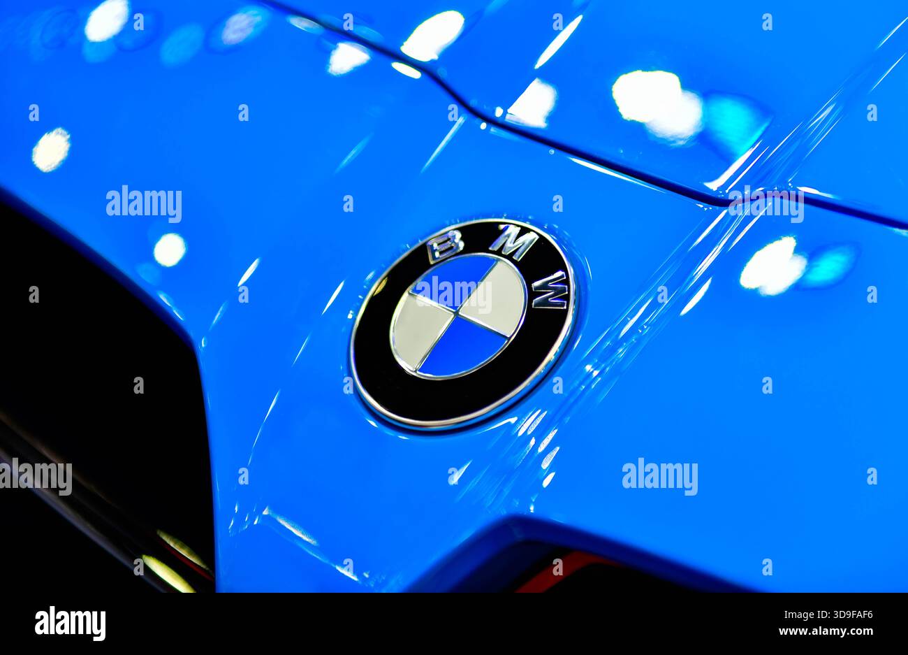 BANGKOK - 1. Dezember 2025: Auf der Motormesse IMPACT Challenge wird auf der Motorhaube eines blauen Autos das ikonische BMW-Logo mit blau-weißen Quadranten ausgestellt Stockfoto