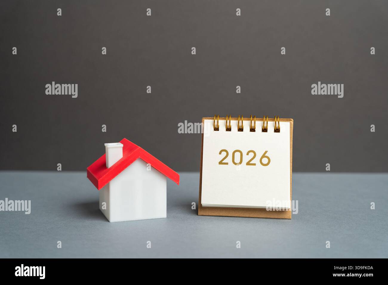 Inschrift 2026 und Miniaturhaus. Familienhaushaltsplanung für nächstes Jahr. Investitionen, Pläne, Einsparungen. Hypothekenzinsen. Immobilienkonzept. Refinanc Stockfoto