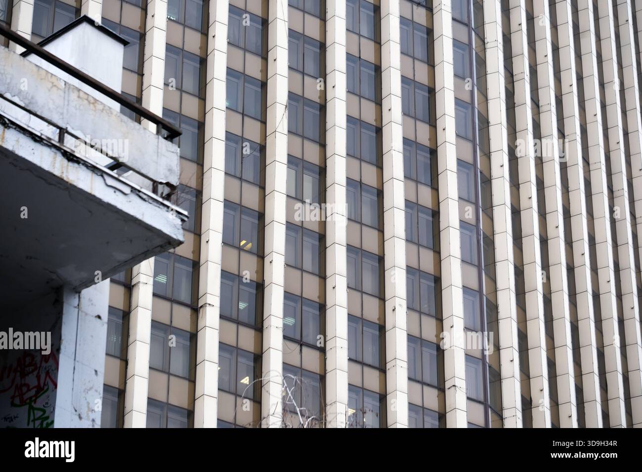Das hohe Gebäude mit geometrischen Mustern spiegelt das Stadtleben und die Einsamkeit der Stadt wider. Stockfoto