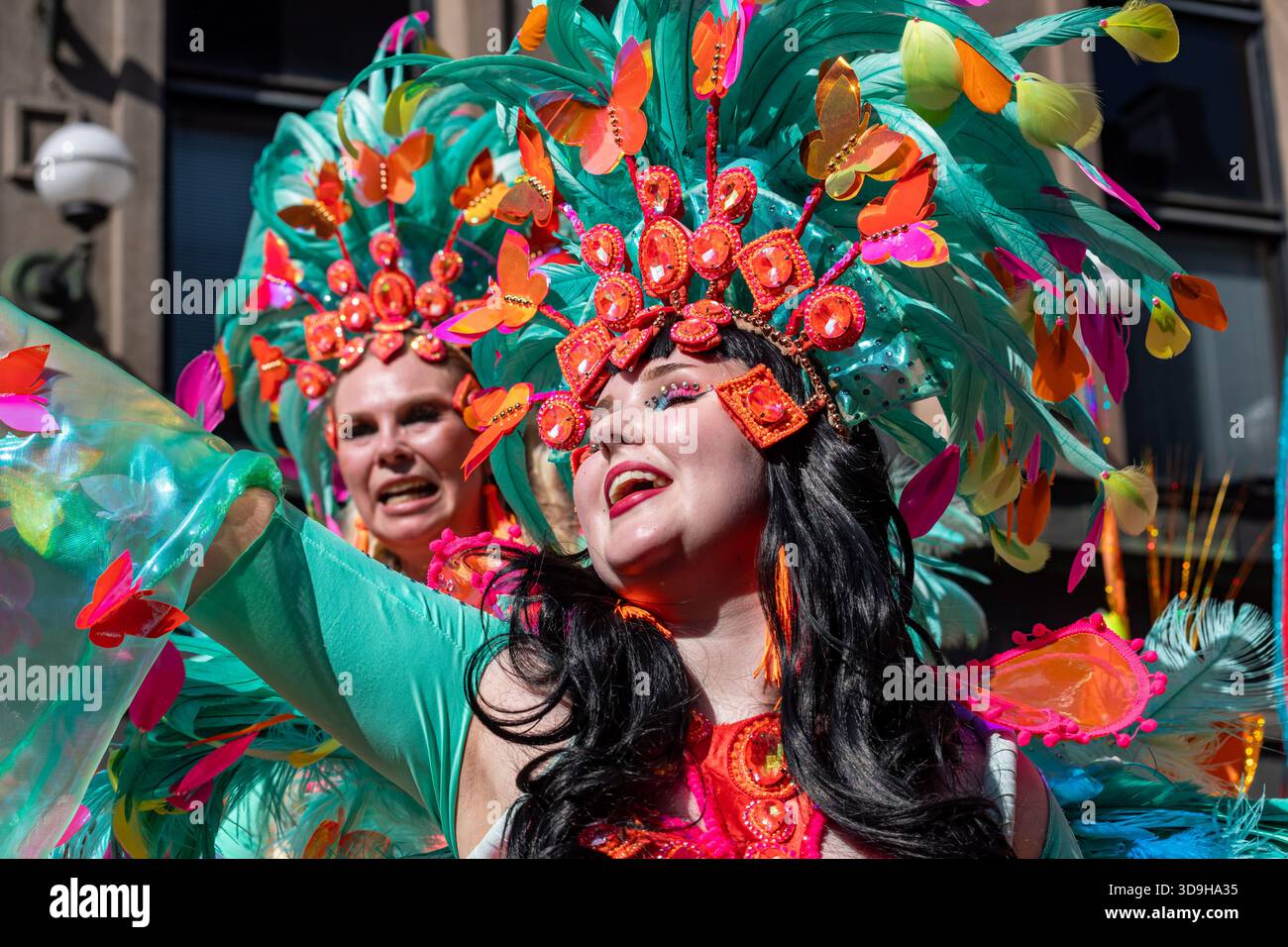 Samba-Tänzer mit feurigen Kopfbedeckungen und bunten Kostümen im Helsinki Samba Carnaval auf Aleksanterinkatu im Bezirk Kluuvi in Helsinki, Finnland Stockfoto