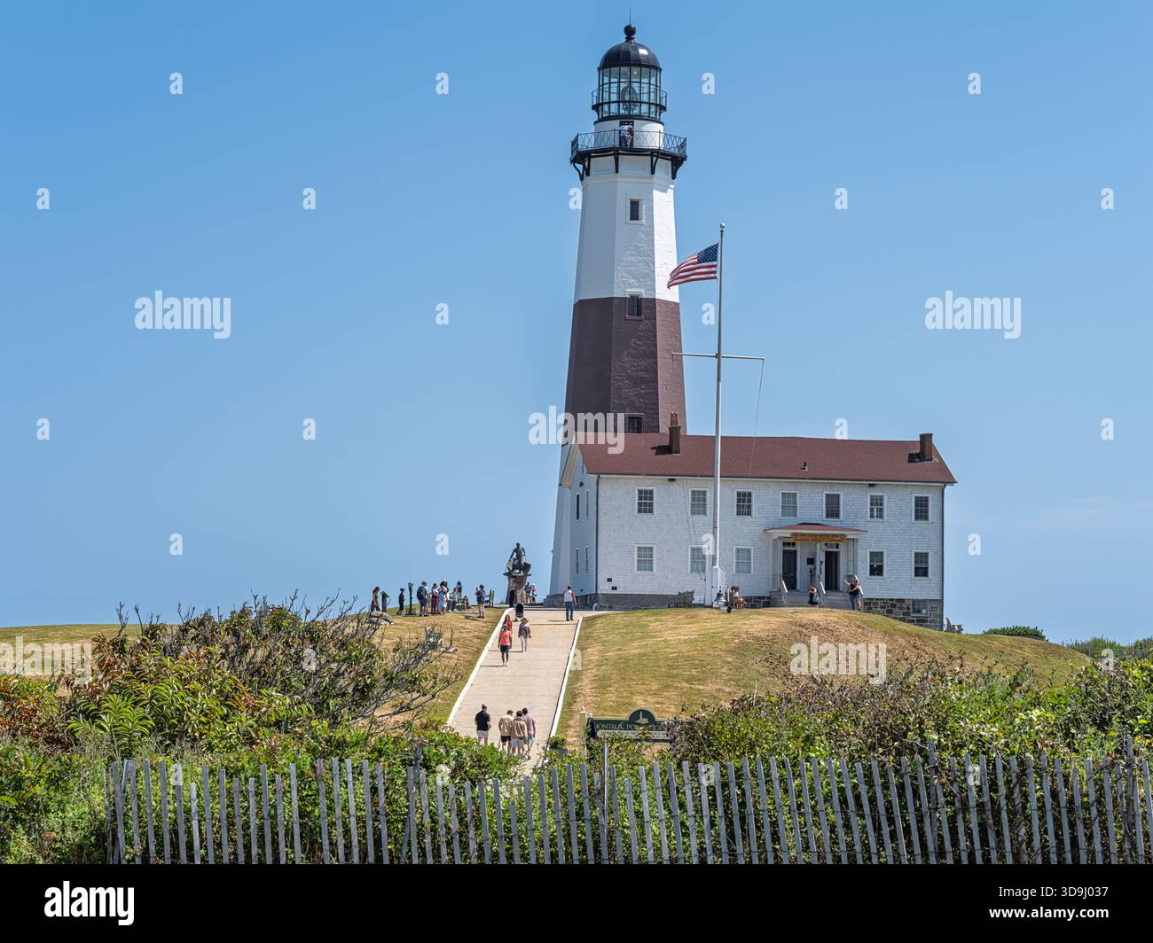 Montauk Point Lighthouse mit Besuchern an einem klaren Sommernachmittag in Montauk, Long Island, New York, einem historischen Wahrzeichen an der Ostspitze der Insel. Stockfoto