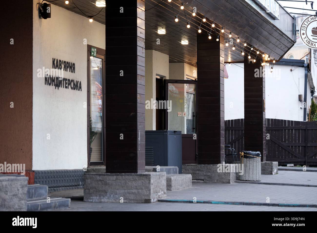 Besucher können sich in einem gemütlichen Café mit warmen Lichtern und einladender Atmosphäre entspannen. Kiew, Ukraine. Dezember 2025. Stockfoto