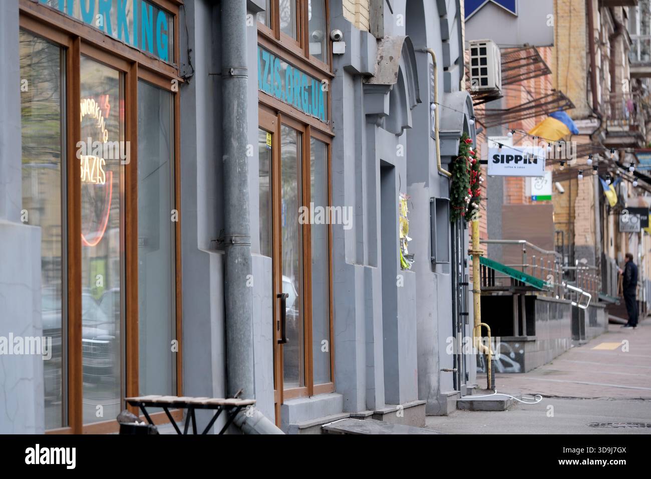 Farbenfrohe Schaufensterfassaden säumen die belebte Straße und laden zum Erkunden ein. Kiew, Ukraine. Dezember 2025. Stockfoto