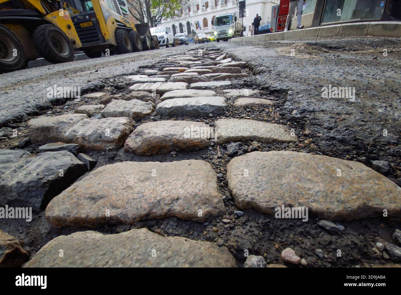Bukarest, Rumänien. 2. Dezember 2025: Das alte Kopfsteinpflaster wird unter dem ausgebauten Bürgersteig in der Academiei Street gesehen. Stockfoto