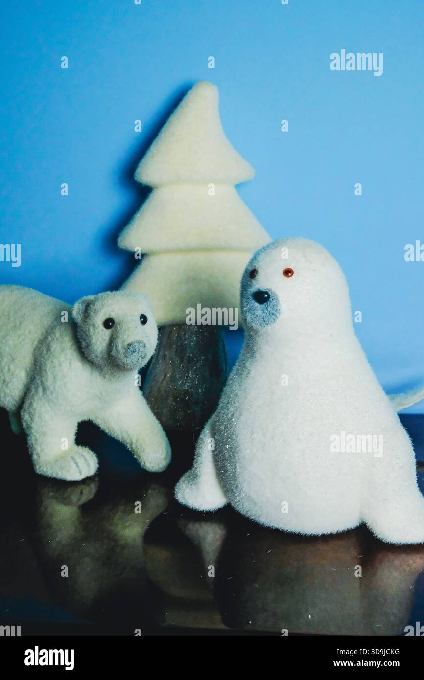 Verspielte Reproduktionen von Eisbär und Robbensiegel bilden eine Weihnachtskomposition Stockfoto