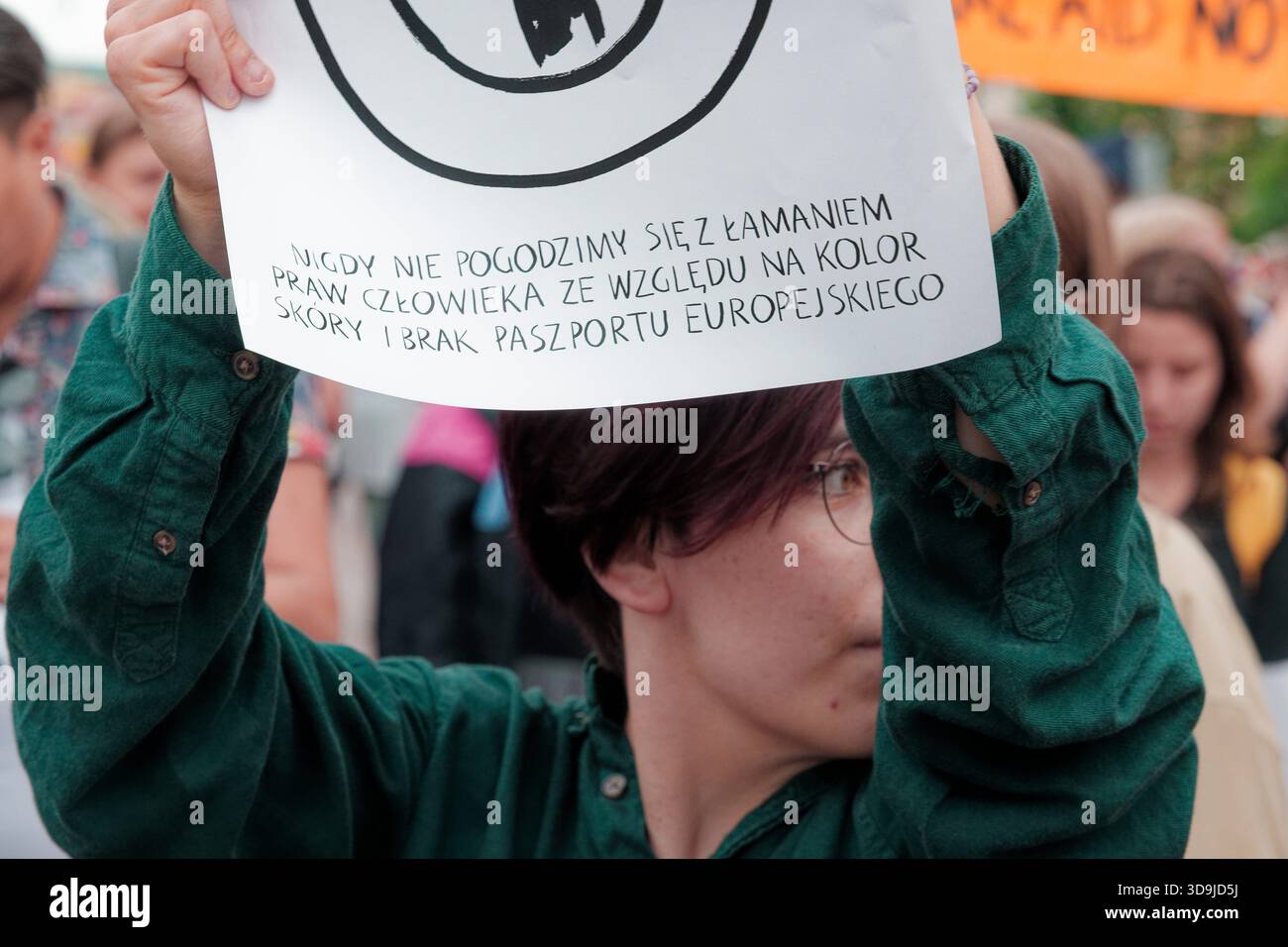 Der Demonstrant hält ein Zeichen gegen Diskriminierung während einer Menschenrechtsdemonstration in einer überfüllten Straße. Stockfoto