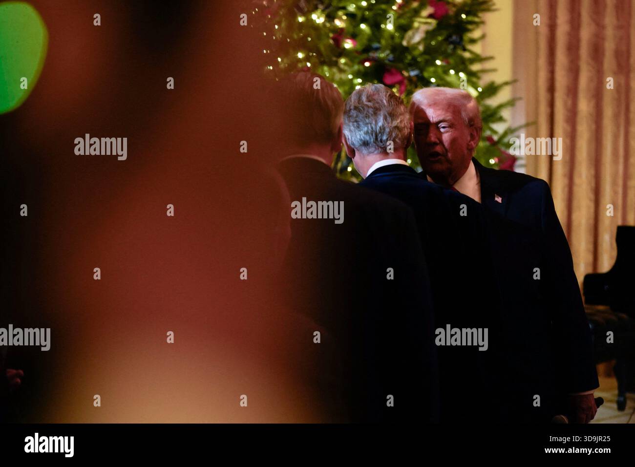 Präsident Donald Trump flüstert Andrea Bocelli ins Ohr vor einem Konzert von Andrea Bocelli im East Room des Weißen Hauses am Freitag, 5. Dezember 2025 in Washington, DC. (Foto: Leigh Vogel/Pool/ABACAPRESS.COM) Credit: Abaca Press/Alamy Live News Stockfoto