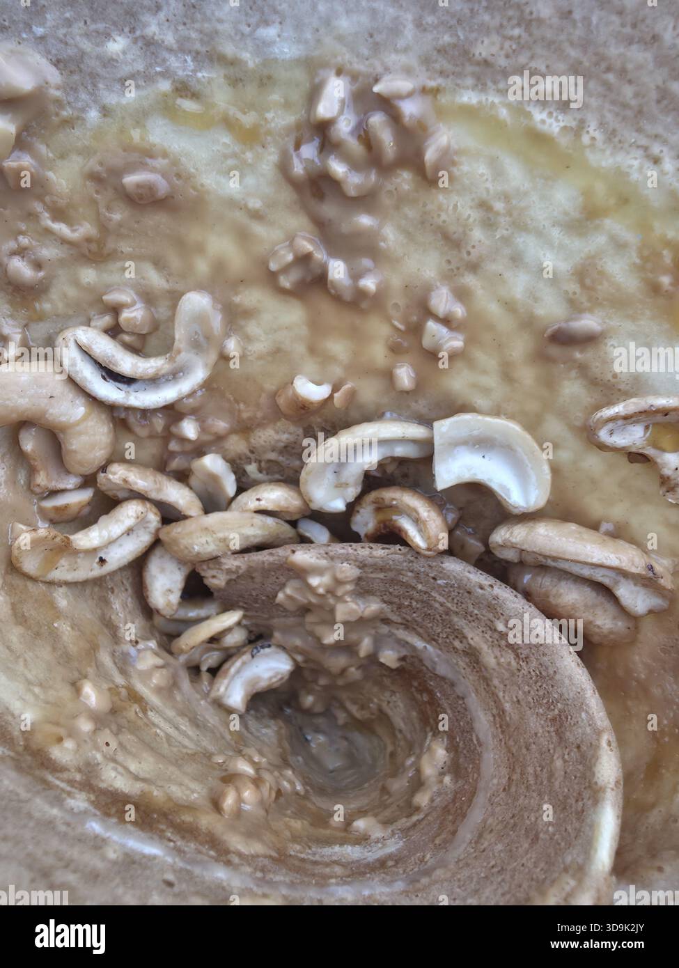 Reichhaltiger, cremiger Strudel aus köstlichem Karamell-Fudge mit knusprigen Cashewnüssen. Ein abstrakter Essenshintergrund, der süße, verlockende und leckere Textur von Hom zeigt Stockfoto