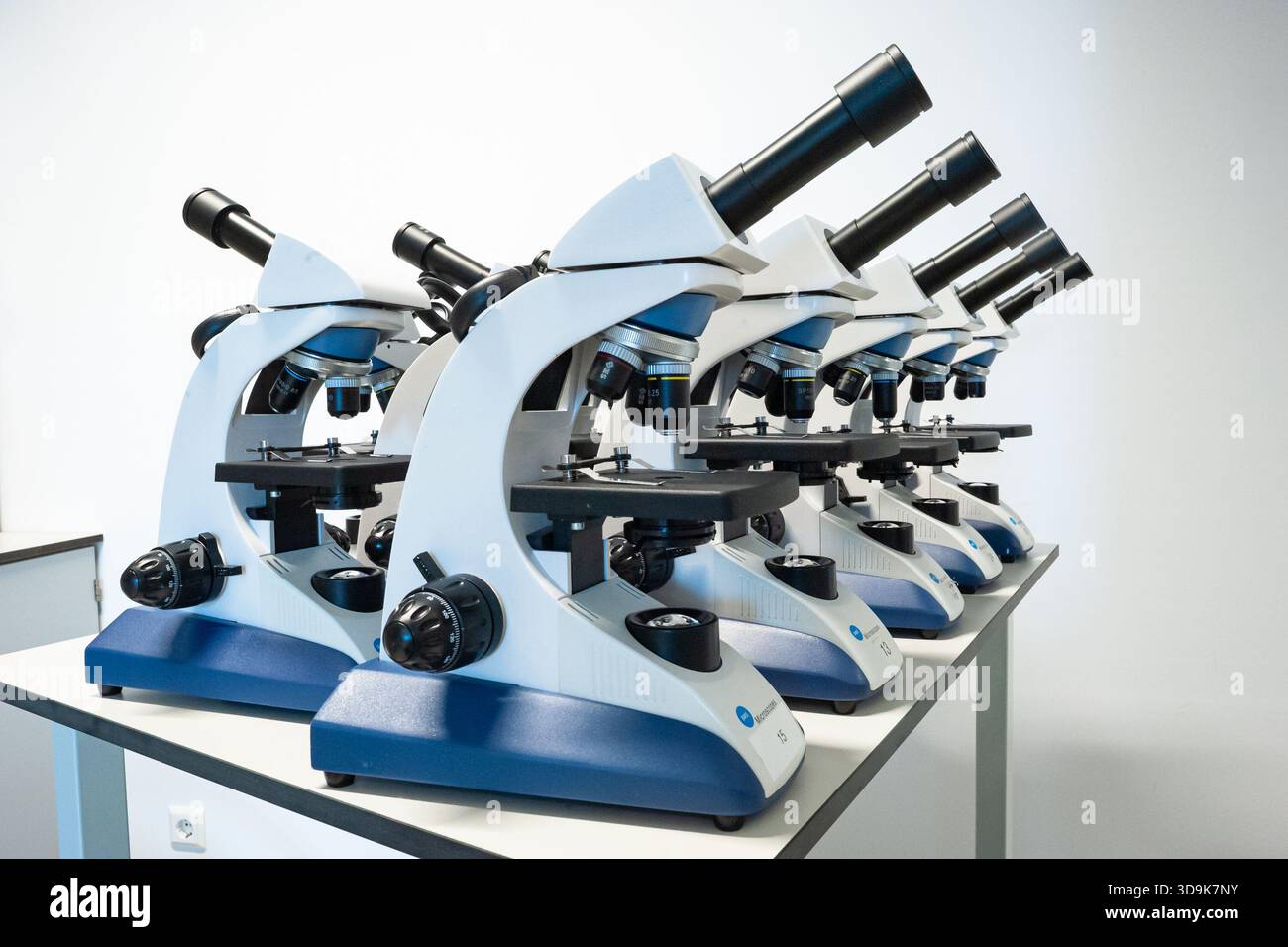 Mikroskope reiften in einem Schullabor, bereit für Biologiestunden und Studentenforschung Stockfoto