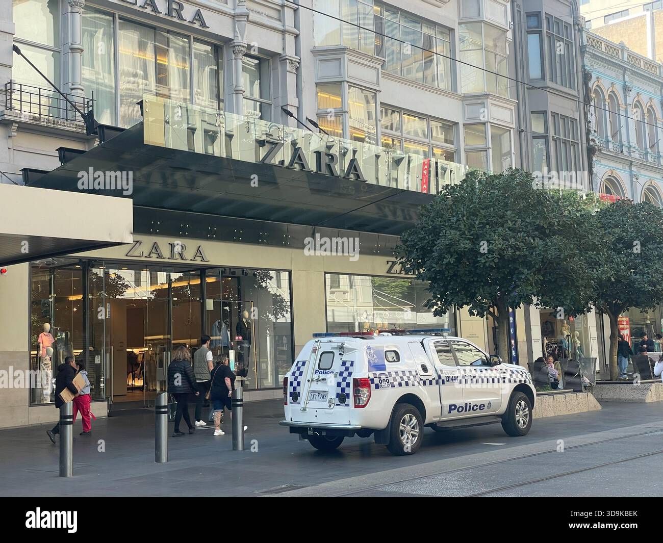 Ein Van der Victoria Police parkt vor einem Zara-Geschäft in Melbourne, Australien, mit Fußgängern in der Nähe. Stockfoto