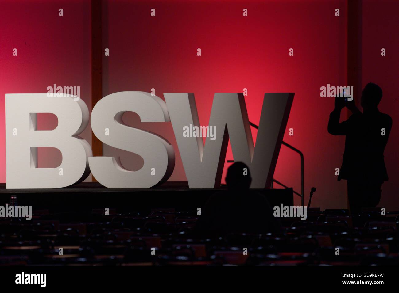 Magdeburg, Deutschland. Dezember 2025. Ein Teilnehmer der 3. Bundesparteikonferenz des BSW steht vor großen Briefen auf der Bühne der Parteikonferenz und macht Fotos. In Magdeburg beginnt die 3. Bundesparteikonferenz der BSW. Unter anderem will sich die Partei bei der Delegiertenversammlung einen neuen Namen geben. Quelle: Klaus-Dietmar Gabbert/dpa/Alamy Live News Stockfoto