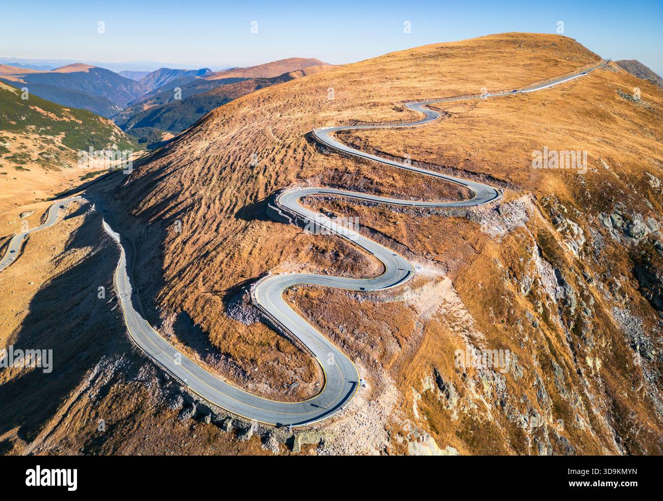 Transalpina, Rumänien. Auf höchster Höhe kurvige Straße, die die rumänischen Karpaten auf 2145 m Höhe überquert - blauer Himmel im oktober. Stockfoto